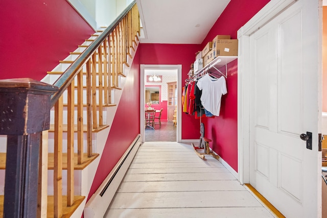 staircase featuring a baseboard radiator and hardwood / wood-style flooring