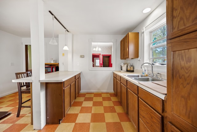 kitchen featuring hanging light fixtures, sink, a chandelier, and light tile floors