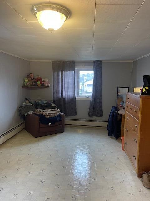 bedroom with a baseboard heating unit and ornamental molding