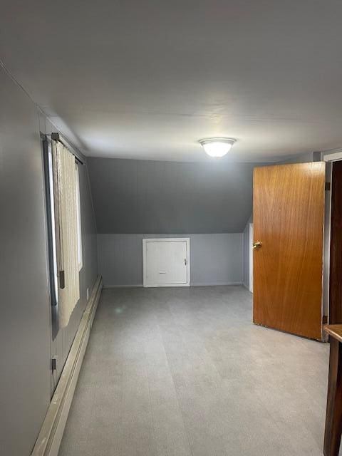 additional living space with lofted ceiling and a baseboard heating unit