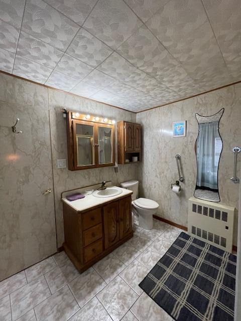 bathroom with toilet, vanity, and radiator heating unit