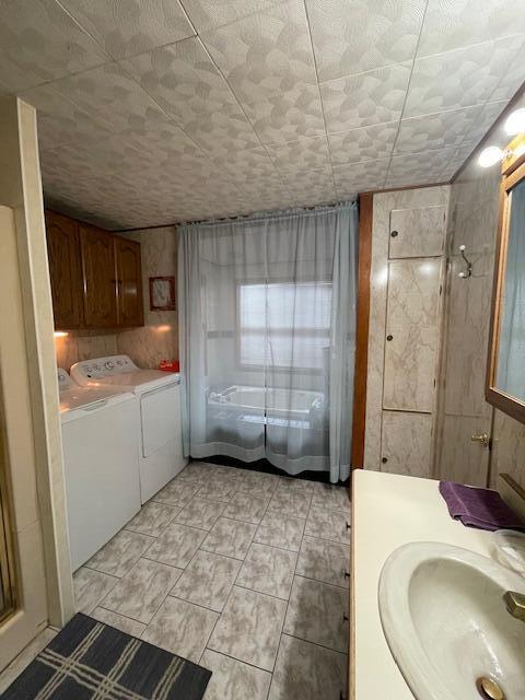 bathroom featuring washer and dryer, tile patterned floors, a shower, and vanity