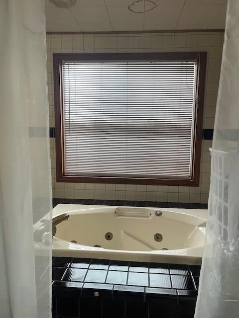 bathroom featuring a relaxing tiled tub