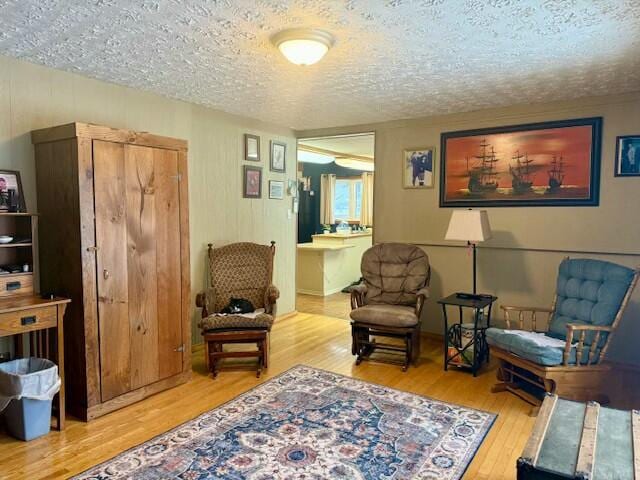 sitting room with a textured ceiling and hardwood / wood-style floors