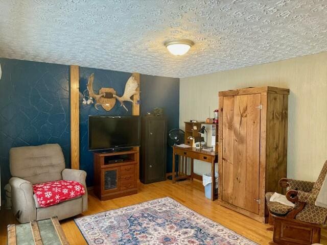 living area with a textured ceiling and hardwood / wood-style flooring