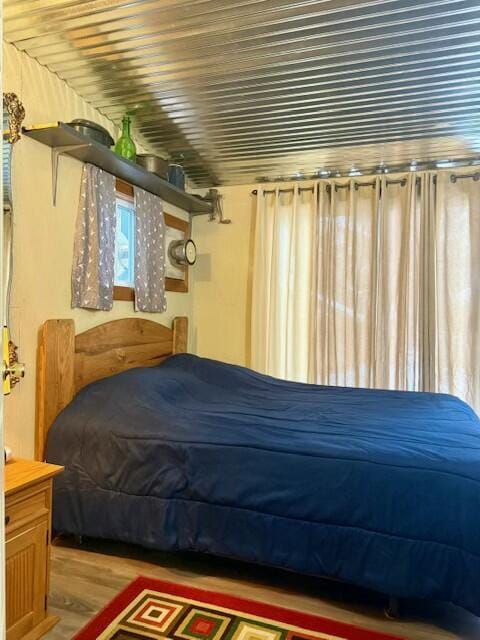 bedroom with light hardwood / wood-style floors and multiple windows