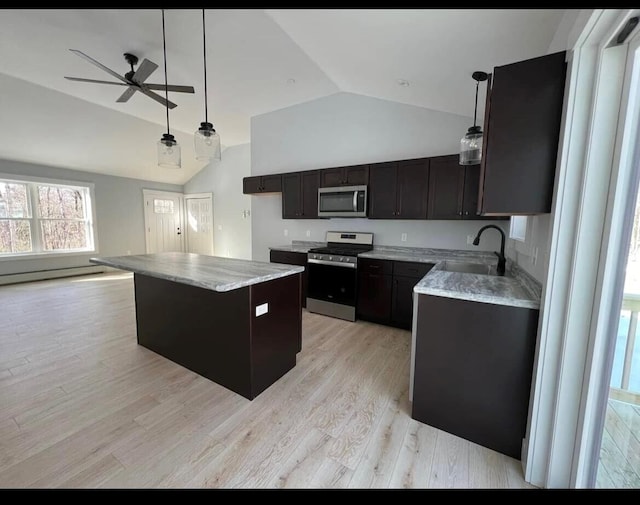 kitchen featuring vaulted ceiling, stainless steel appliances, ceiling fan, a center island, and sink