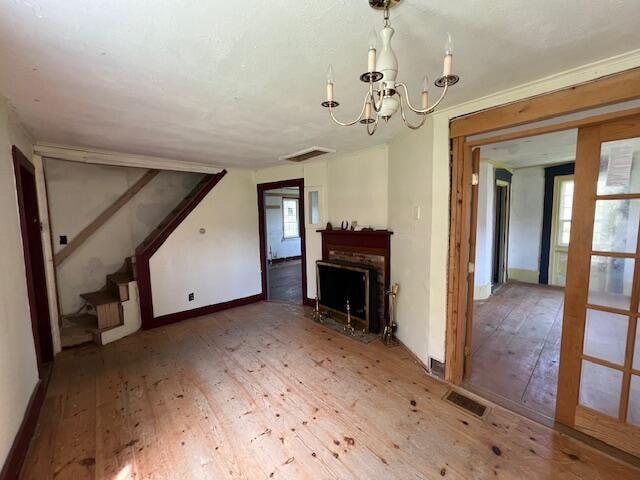 unfurnished living room featuring a chandelier and wood-type flooring