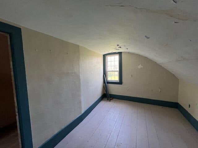 additional living space featuring hardwood / wood-style flooring and vaulted ceiling