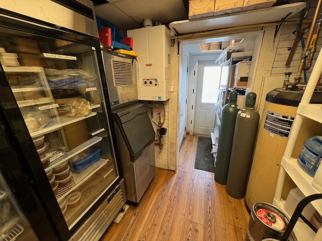 9 Tenney Hill Rd, Monson, ME 04464 - kitchen with a paneled ceiling, gas water heater, fridge, and hardwood / wood-style floors