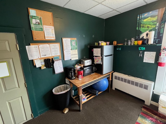 9 Tenney Hill Rd, Monson, ME 04464 - interior space featuring carpet flooring, radiator heating unit, and a drop ceiling