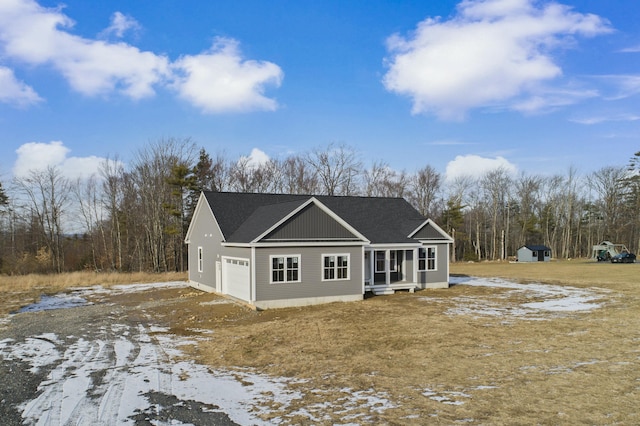 view of front facade featuring a garage and a storage shed