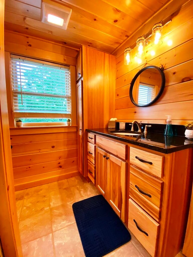 bathroom featuring wood ceiling, tile floors, wooden walls, and vanity with extensive cabinet space