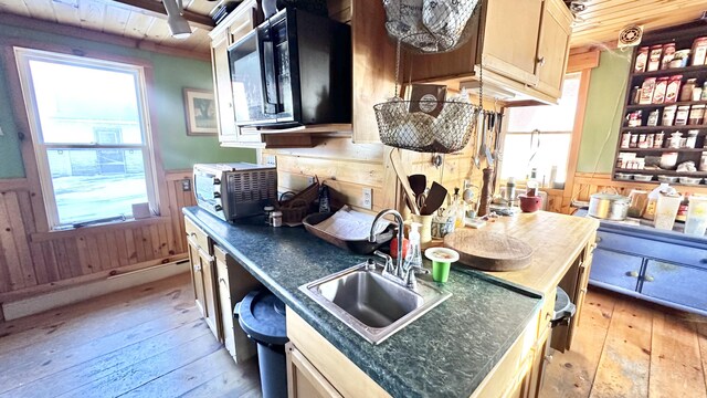 kitchen with sink, light brown cabinets, wood walls, light hardwood / wood-style floors, and wood ceiling