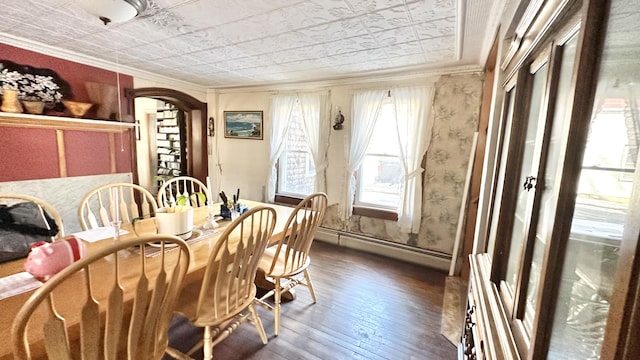 dining space featuring baseboard heating, crown molding, and dark wood-type flooring