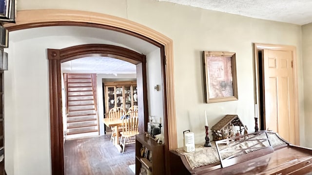 hallway featuring hardwood / wood-style flooring and a textured ceiling