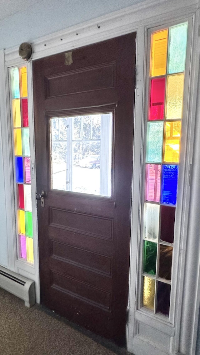 doorway to outside featuring a baseboard heating unit