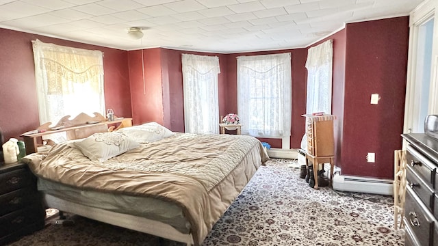 bedroom with carpet and a baseboard heating unit