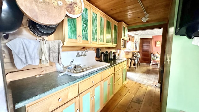 kitchen featuring light brown cabinets, light hardwood / wood-style floors, wooden ceiling, and sink