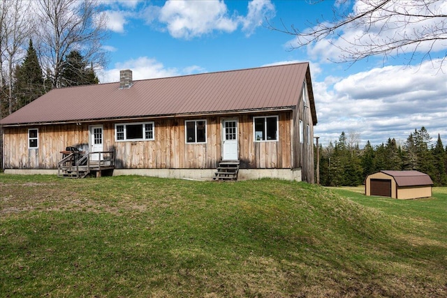 rear view of house with an outdoor structure and a lawn