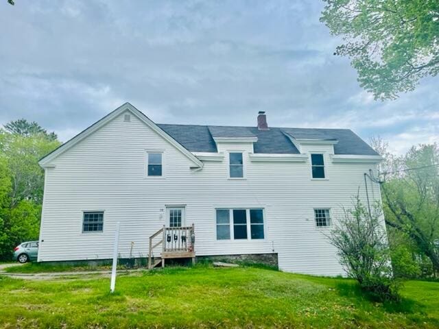 rear view of house featuring a yard