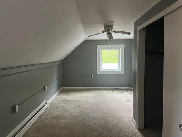 additional living space with a baseboard radiator, lofted ceiling, carpet, and ceiling fan