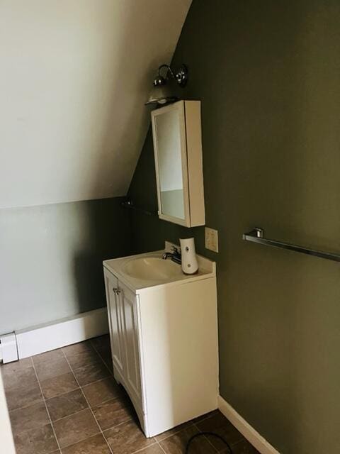 bathroom featuring tile flooring, lofted ceiling, and large vanity