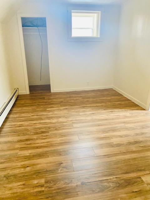 spare room with a baseboard radiator and light wood-type flooring