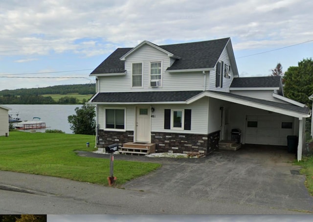 view of front of house featuring a front lawn, a carport, and a water view