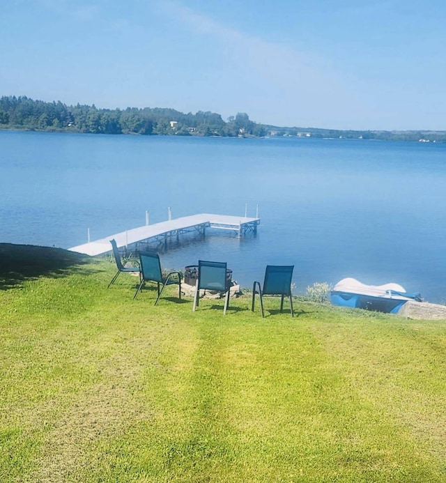 dock area featuring a lawn and a water view