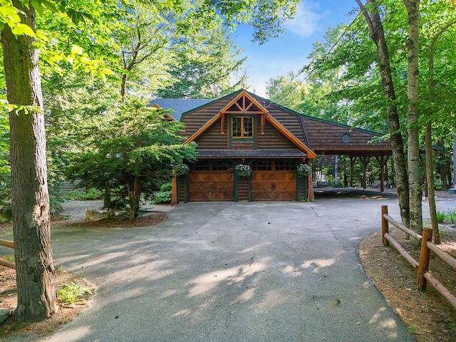 view of front of home featuring faux log siding and driveway
