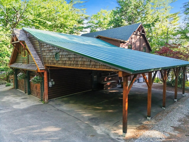 view of side of home with central air condition unit, metal roof, and a carport