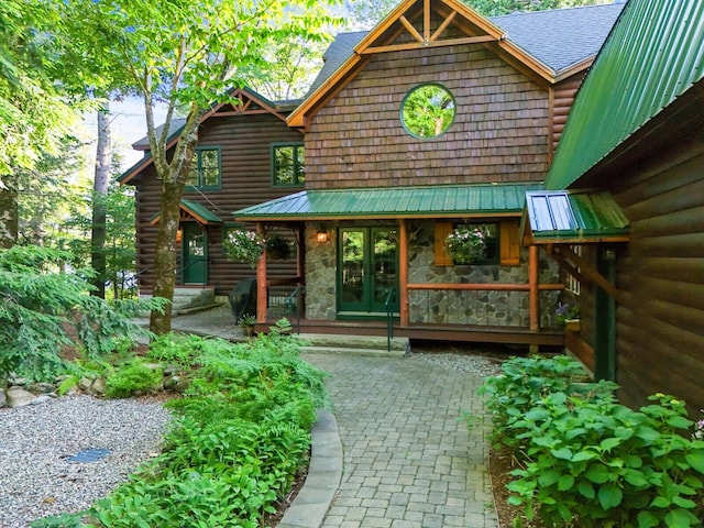 exterior space featuring stone siding and french doors