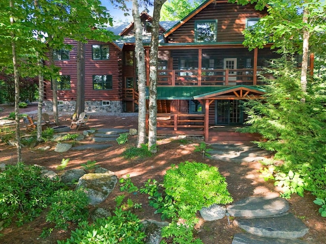 view of front facade with log exterior and a wooden deck