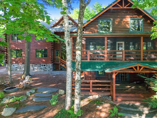 rear view of property featuring a sunroom and log siding