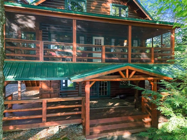 exterior space with an outbuilding, a sunroom, an exterior structure, and metal roof