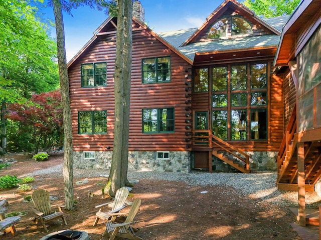 exterior space featuring crawl space, a chimney, and log exterior