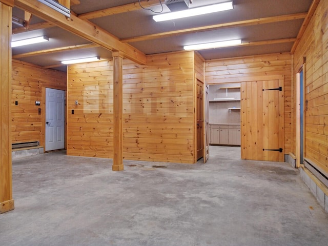 empty room with concrete flooring and wooden walls