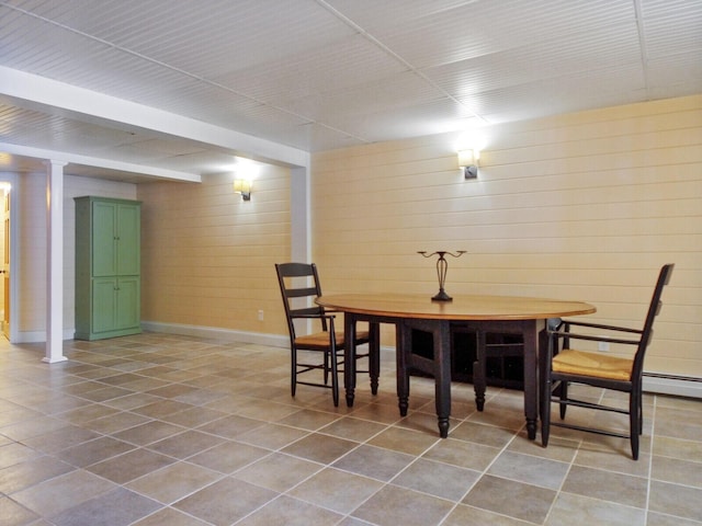 tiled dining space featuring baseboards