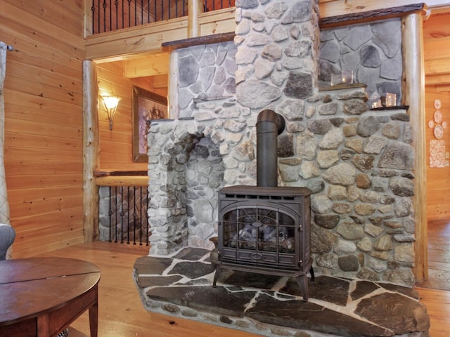 details with a wood stove, wooden walls, and wood finished floors