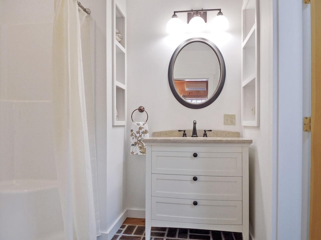 bathroom with a shower with shower curtain, baseboards, and vanity
