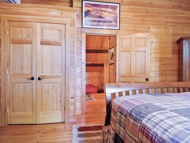 bedroom featuring wood walls and wood finished floors