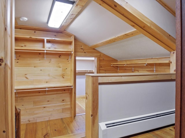 spacious closet with a baseboard radiator, vaulted ceiling, and hardwood / wood-style flooring