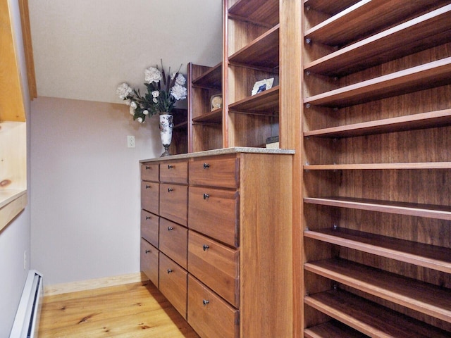 spacious closet featuring light wood-style flooring and baseboard heating
