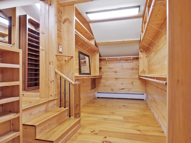 spacious closet featuring a baseboard heating unit and wood-type flooring
