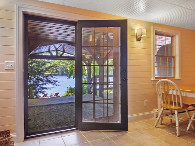 entryway featuring tile patterned flooring and wooden walls