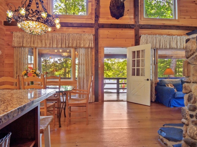 dining room with a high ceiling, wood walls, and hardwood / wood-style floors
