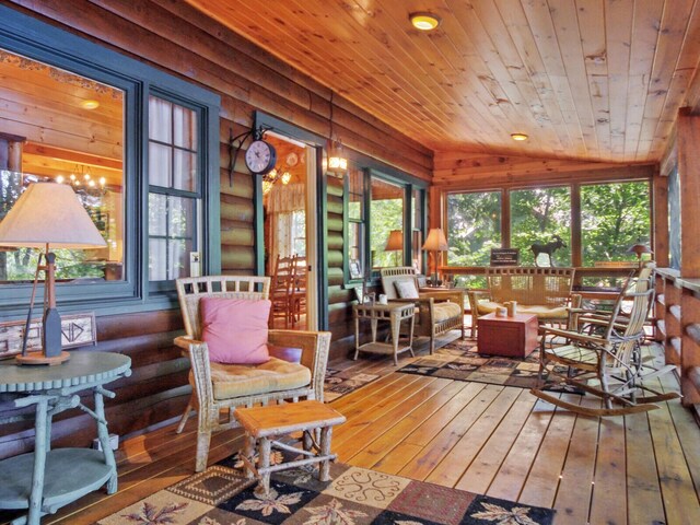 sunroom / solarium featuring wooden ceiling, plenty of natural light, and vaulted ceiling