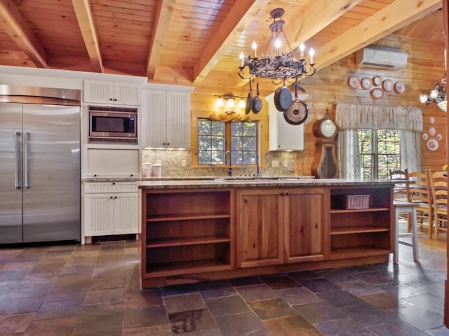 kitchen featuring a wall mounted air conditioner, a notable chandelier, open shelves, and built in appliances