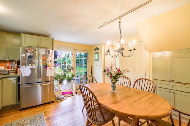 dining area featuring light hardwood / wood-style flooring and a notable chandelier